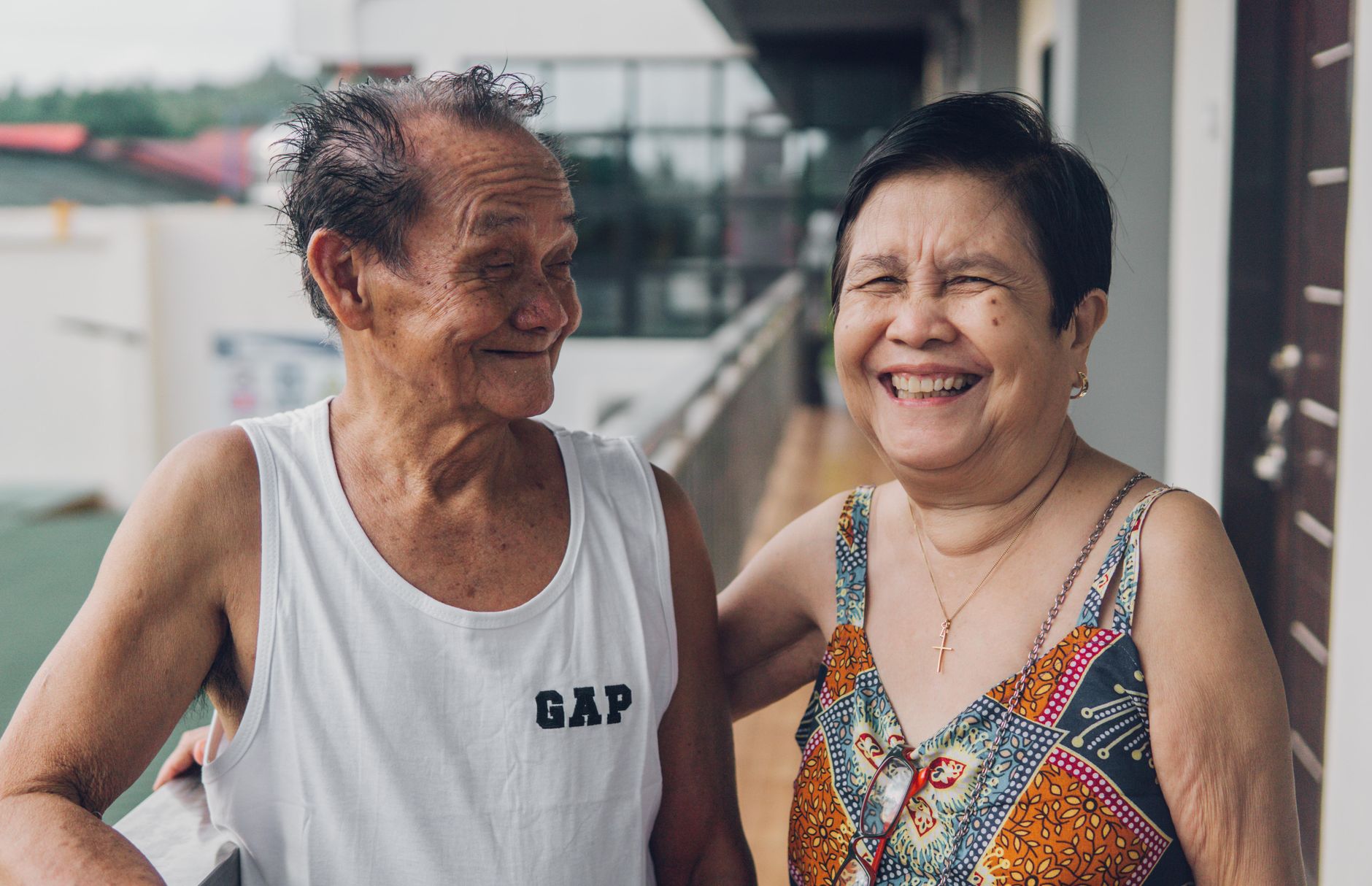 Happy elderly couple laughing outdoors in a park in Singapore
